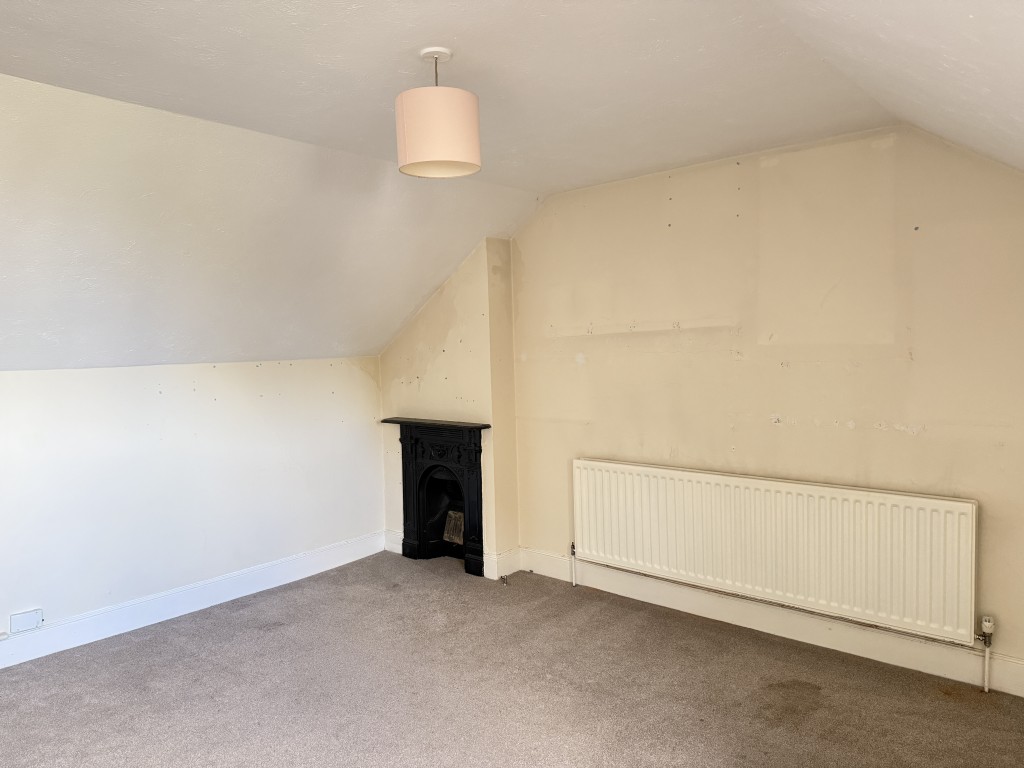 Lot: 28 - ONE-BEDROOM LEASEHOLD FLAT IN NEED OF IMPROVEMENT WITH SHARE OF FREEHOLD - Living room with painted walls and carpet